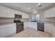 Modern kitchen with stainless steel appliances, white cabinets, and tiled flooring at 11120 Whooping Crane Ln, Las Vegas, NV 89144