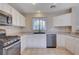 Well-lit kitchen equipped with stainless steel appliances and white cabinets at 11120 Whooping Crane Ln, Las Vegas, NV 89144
