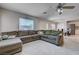 Open-concept living room leading to the dining area with a large comfortable sectional sofa at 11120 Whooping Crane Ln, Las Vegas, NV 89144