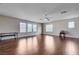 Bright living room with wood floors, a ceiling fan, and natural light streaming in from multiple windows at 11120 Whooping Crane Ln, Las Vegas, NV 89144