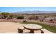 Landscaped backyard featuring an outdoor stone table with seating and desert landscaping, perfect for enjoying mountain views at 1348 Basin Vw, Mesquite, NV 89034
