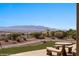 Landscaped backyard with mountain views, artificial grass, and a stone table with seating, ideal for outdoor relaxation at 1348 Basin Vw, Mesquite, NV 89034