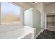 Bright bathroom with a white soaking tub and glass enclosed shower near a window at 1348 Basin Vw, Mesquite, NV 89034