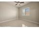 This bedroom has tile floors, a window with blinds, and a ceiling fan with a light at 1348 Basin Vw, Mesquite, NV 89034