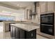 Well-lit kitchen featuring an island, stainless steel oven and range hood, with scenic views through the windows at 1348 Basin Vw, Mesquite, NV 89034