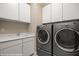 Laundry room with gray washer and dryer and white storage cabinets at 1348 Basin Vw, Mesquite, NV 89034