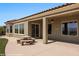 Covered patio featuring a decorative stone table and attached benches overlooking the manicured backyard at 1348 Basin Vw, Mesquite, NV 89034