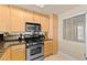 Well-lit kitchen featuring stainless steel appliances and wooden cabinetry at 220 E Flamingo Rd # 111, Las Vegas, NV 89169
