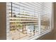 View of palm-lined pool area from inside home through window with horizontal blinds at 220 E Flamingo Rd # 111, Las Vegas, NV 89169