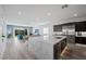 Spacious kitchen with quartz island, stainless appliances, dark cabinets, and open concept layout to the living room at 298 Watteau Ct, Henderson, NV 89012