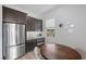 Kitchenette with stainless steel refrigerator, dark wood cabinetry, and adjacent dining table at 298 Watteau Ct, Henderson, NV 89012