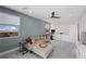 Comfortable living room with blue accent wall, ceiling fan, and backyard view at 298 Watteau Ct, Henderson, NV 89012