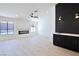 Open living space featuring a modern fireplace, sleek bar area, and ample natural light at 3156 Shadowridge Ave, Las Vegas, NV 89120
