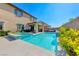 Luxurious backyard featuring a swimming pool, spa, covered patio, and desert landscaping at 3360 Lochside Dr, Henderson, NV 89044