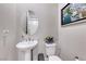 This is a charming powder room featuring a pedestal sink, toilet, oval mirror, and neutral decor at 3360 Lochside Dr, Henderson, NV 89044