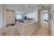 Open-concept living area with neutral carpet, railing, and inviting layout leading to other rooms at 3360 Lochside Dr, Henderson, NV 89044