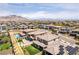 This aerial view showcases a community with pools, green lawns, and mountain backdrops at 395 Prairie Sun St, Las Vegas, NV 89138