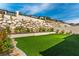 Lush backyard with meticulously manicured turf and tasteful landscaping, enhanced by an attractive retaining wall feature at 395 Prairie Sun St, Las Vegas, NV 89138