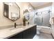 Elegant bathroom featuring dual sinks, modern fixtures, and a shower-over-tub with glass door at 395 Prairie Sun St, Las Vegas, NV 89138