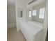 Bright bathroom featuring a large mirror, a bathtub with shower, and white cabinets at 520 Shire Hall St, Las Vegas, NV 89178