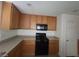 Well-lit kitchen with wooden cabinets and black appliances, offering a practical design at 520 Shire Hall St, Las Vegas, NV 89178
