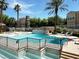 Community pool area featuring a tiered fountain, lounge chairs, and black wrought-iron fencing at 10001 Peace Way # 2277, Las Vegas, NV 89147