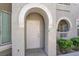 The covered entrance features a private front door, enhanced by attractive architectural details and landscaping at 10001 Peace Way # 2277, Las Vegas, NV 89147