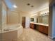 Bathroom showcasing a large soaking tub, double vanity, and walk-in closet at 10013 Scenic Walk Ave, Las Vegas, NV 89149