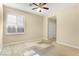 Cozy bedroom featuring a large window, neutral walls, plush carpeting, and a ceiling fan creating a calming and comfortable retreat at 10013 Scenic Walk Ave, Las Vegas, NV 89149