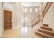Bright foyer with tile floors, a wooden front door, and staircase leading to the second floor at 10013 Scenic Walk Ave, Las Vegas, NV 89149