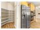 Stainless steel refrigerator is beside the cabinetry and walk-in pantry at 10013 Scenic Walk Ave, Las Vegas, NV 89149