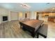 Expansive living space featuring a fireplace, billiard table, hardwood floors, and seamlessly integrates into an open kitchen at 10013 Scenic Walk Ave, Las Vegas, NV 89149