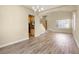 Open-concept living room with modern lighting, wood floors, and neutral wall color at 10013 Scenic Walk Ave, Las Vegas, NV 89149