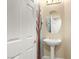Charming powder room with pedestal sink, decorative paint, and white door at 10013 Scenic Walk Ave, Las Vegas, NV 89149