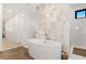 Luxurious bathroom features a soaking tub, tiled walls, and a separate shower area at 10756 Steel Ridge Ct, Las Vegas, NV 89135