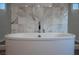 Luxurious soaking tub complemented by elegant marble wall tiling at 10756 Steel Ridge Ct, Las Vegas, NV 89135