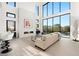 Sunlit living room with floor-to-ceiling windows, a fireplace, and modern decor at 10756 Steel Ridge Ct, Las Vegas, NV 89135