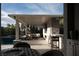 Covered outdoor living with outdoor kitchen, dining, and lounge at 10756 Steel Ridge Ct, Las Vegas, NV 89135