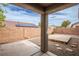 Covered patio looks out on a backyard with low-maintenance gravel and a small wooden stage at 10980 Ampus Pl, Las Vegas, NV 89141