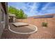 Landscaped backyard showing the deck, covered patio, and stucco wall with solar panels on the roof at 10980 Ampus Pl, Las Vegas, NV 89141