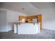 Bright kitchen featuring oak cabinets, a breakfast bar, and open access to the living area at 10980 Ampus Pl, Las Vegas, NV 89141