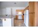 Functional kitchen featuring oak cabinetry, white appliances, and an adjacent breakfast bar, perfect for casual dining at 10980 Ampus Pl, Las Vegas, NV 89141
