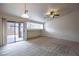 Spacious living room with a sliding glass door to the patio, neutral carpet, and a built-in display niche at 10980 Ampus Pl, Las Vegas, NV 89141