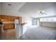 Bright living space featuring an open floor plan with a kitchen bar, ceiling fan, and sliding glass doors at 10980 Ampus Pl, Las Vegas, NV 89141
