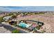 Aerial view of a sparkling community pool and spa with cabanas and lush landscaping in residential area at 10980 Ampus Pl, Las Vegas, NV 89141