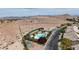 High angle view of community pool with spa, cabanas, and desert landscaping, nestled in residential area at 10980 Ampus Pl, Las Vegas, NV 89141