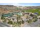 Beautiful aerial view of a clubhouse with a pool, tennis courts and golf course with mountain views at 12 Tatahatso Point St, Henderson, NV 89011