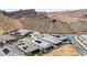 An aerial view of homes featuring desert landscaping and solar panels in a mountainside community at 12 Tatahatso Point St, Henderson, NV 89011