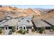 Aerial view of new homes in a desert community with mountain views, solar panels, and driveways at 12 Tatahatso Point St, Henderson, NV 89011
