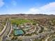 Stunning aerial view of a community with a golf course, pools, tennis courts and mountain views at 12 Tatahatso Point St, Henderson, NV 89011